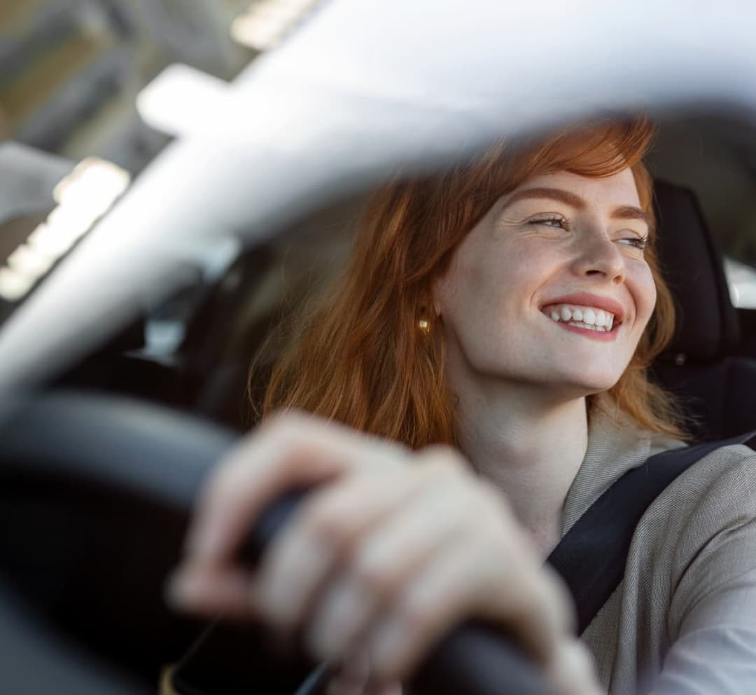 A redhead girl driving a car